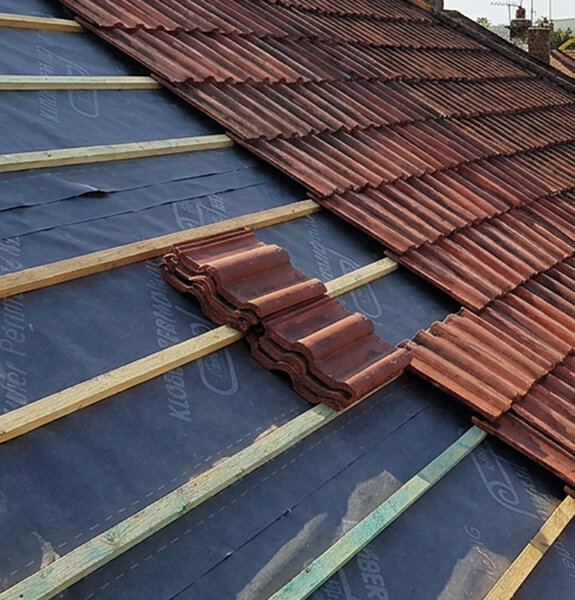 Roof repair being carried out on a tiled roof in Hastings